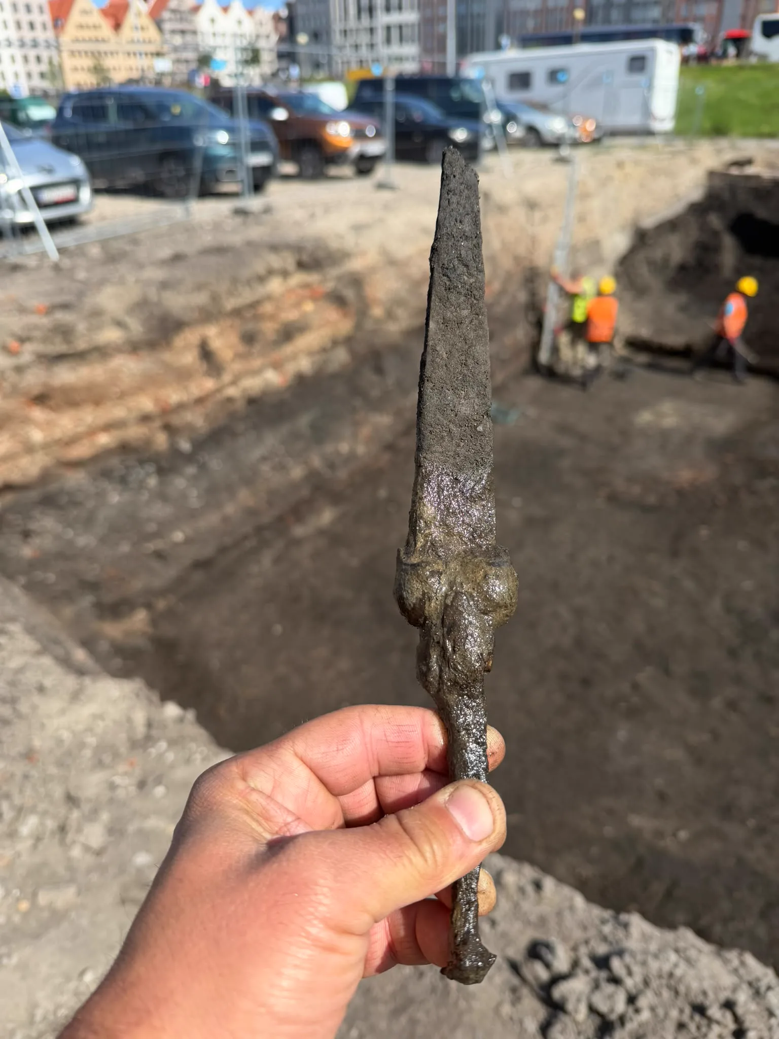 Sztylet typu bollock na tle panoramy Gdańska podczas badań archeologicznych na Wyspie Spichrzów